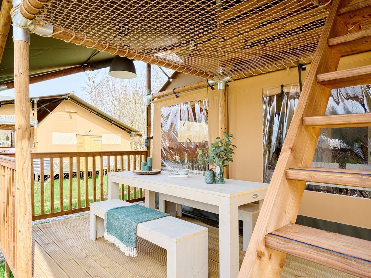 Ruim terras van safaritent 6-8ST in Huizen, met eethoek en uitzicht op de natuur.