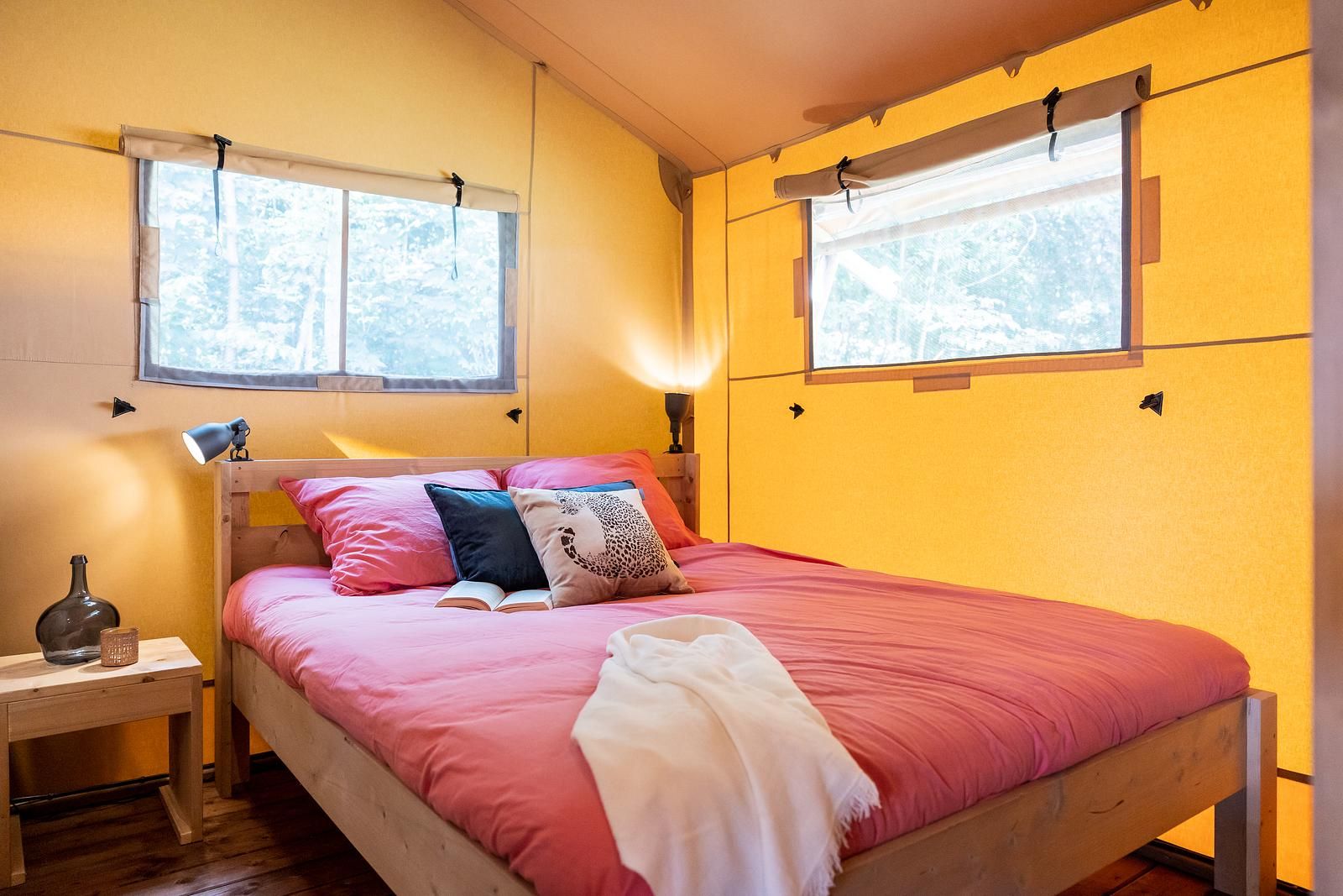 Cozy bedroom in De Bos Tent, an attractive glamping lodge in Huizen, North Holland, with cozy furnishings and natural light.