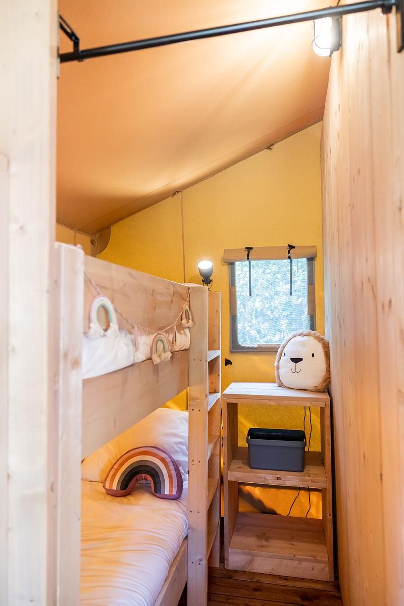 Cozy children's room in De Bos Tent, a glamping lodge in Huizen, North Holland, with bunk beds and playful decorations.