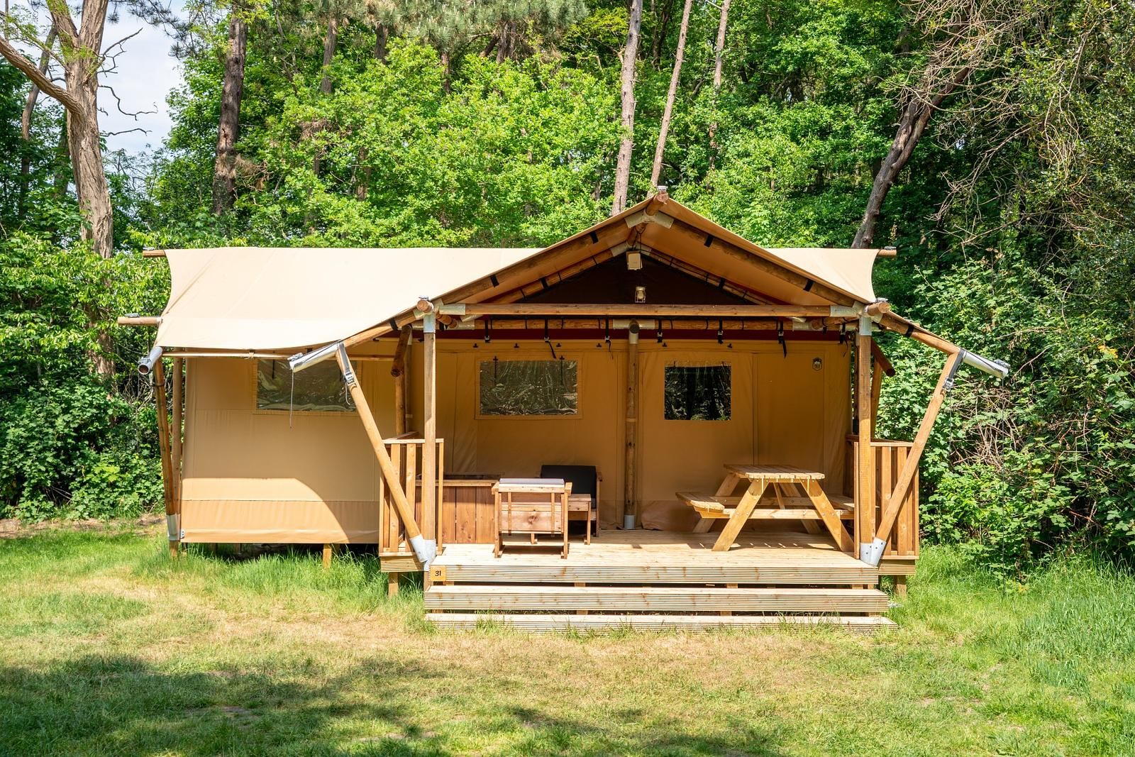 De Heide Tent in Huizen, North Holland offers a cozy glamping experience with an inviting terrace surrounded by green nature.