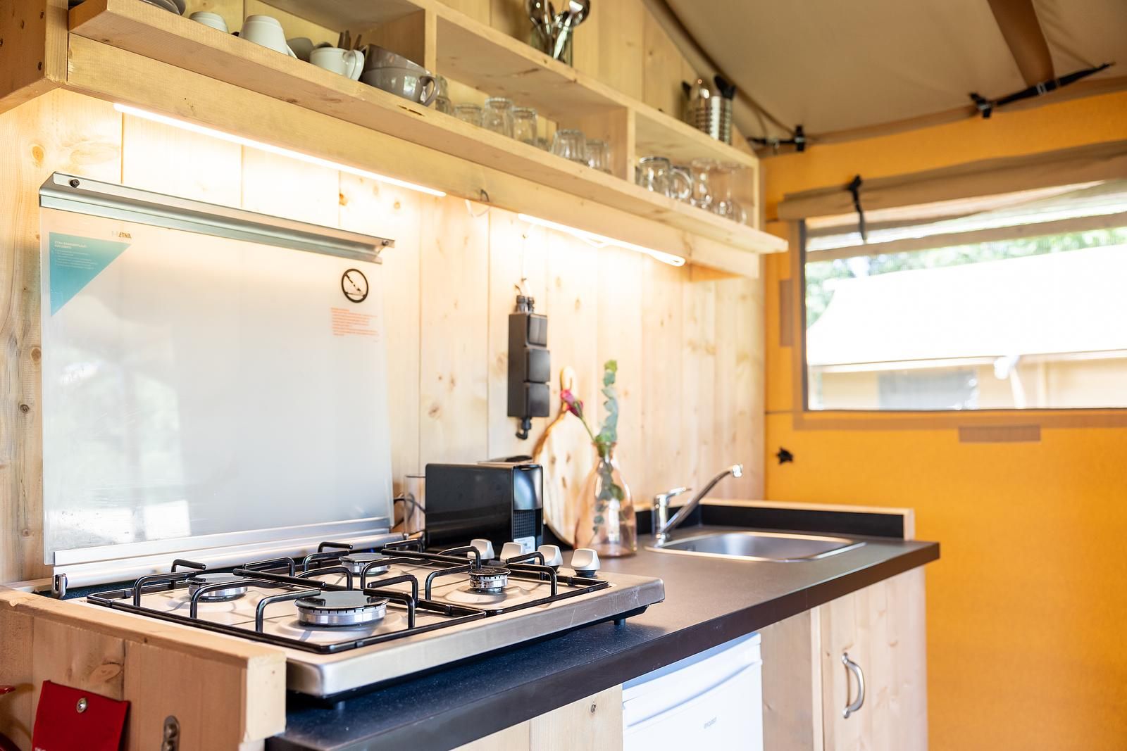 Cozy kitchen in De Bos Tent, an attractive safari tent in Huizen, IJsselmeer coast, North Holland, with modern amenities and natural light.