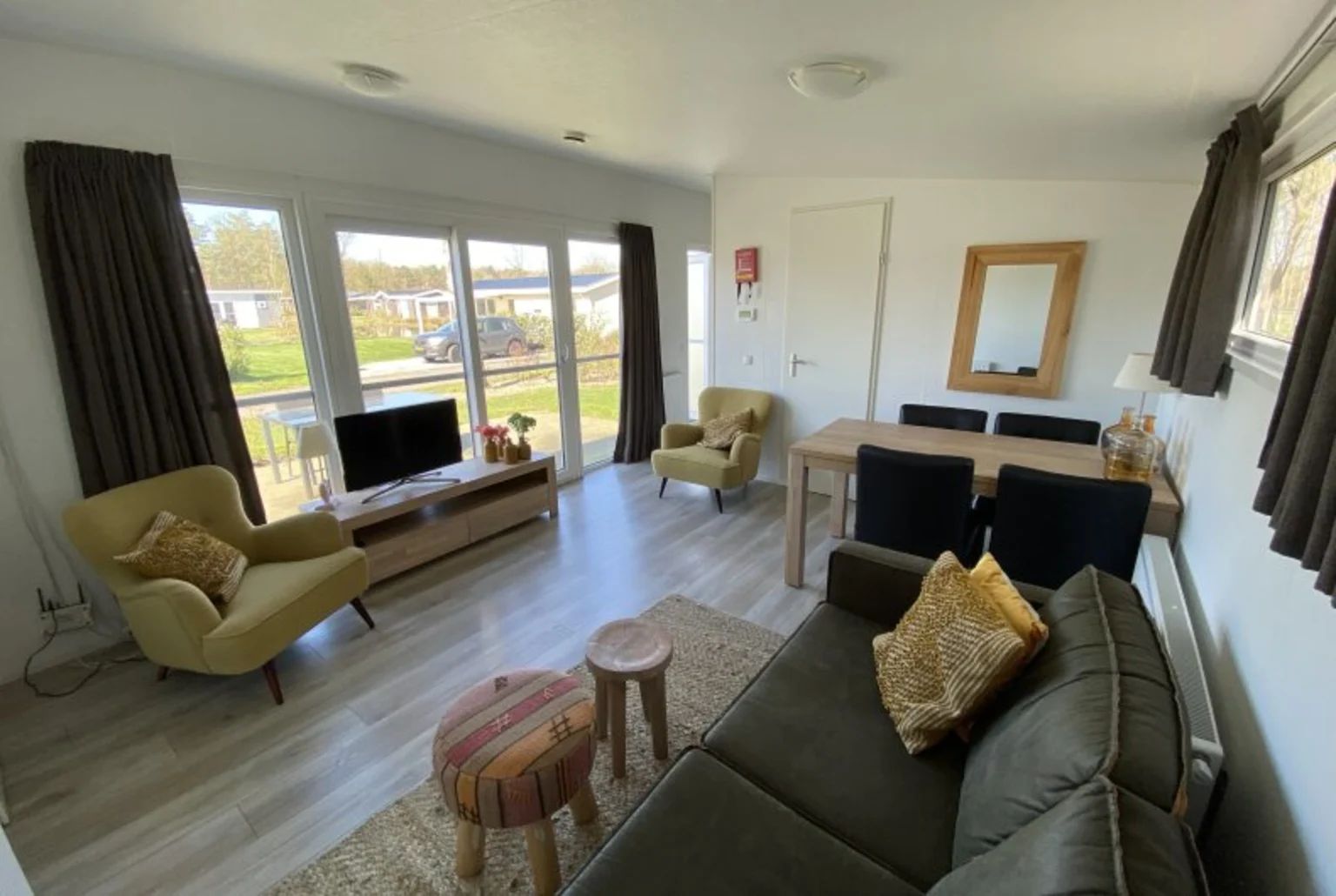 Gemtliches Wohnzimmer im freistehenden Haus in Bovenkarspel, IJsselmeerkste, Nordholland, mit grozgiger Sitzecke und Blick auf den Garten.