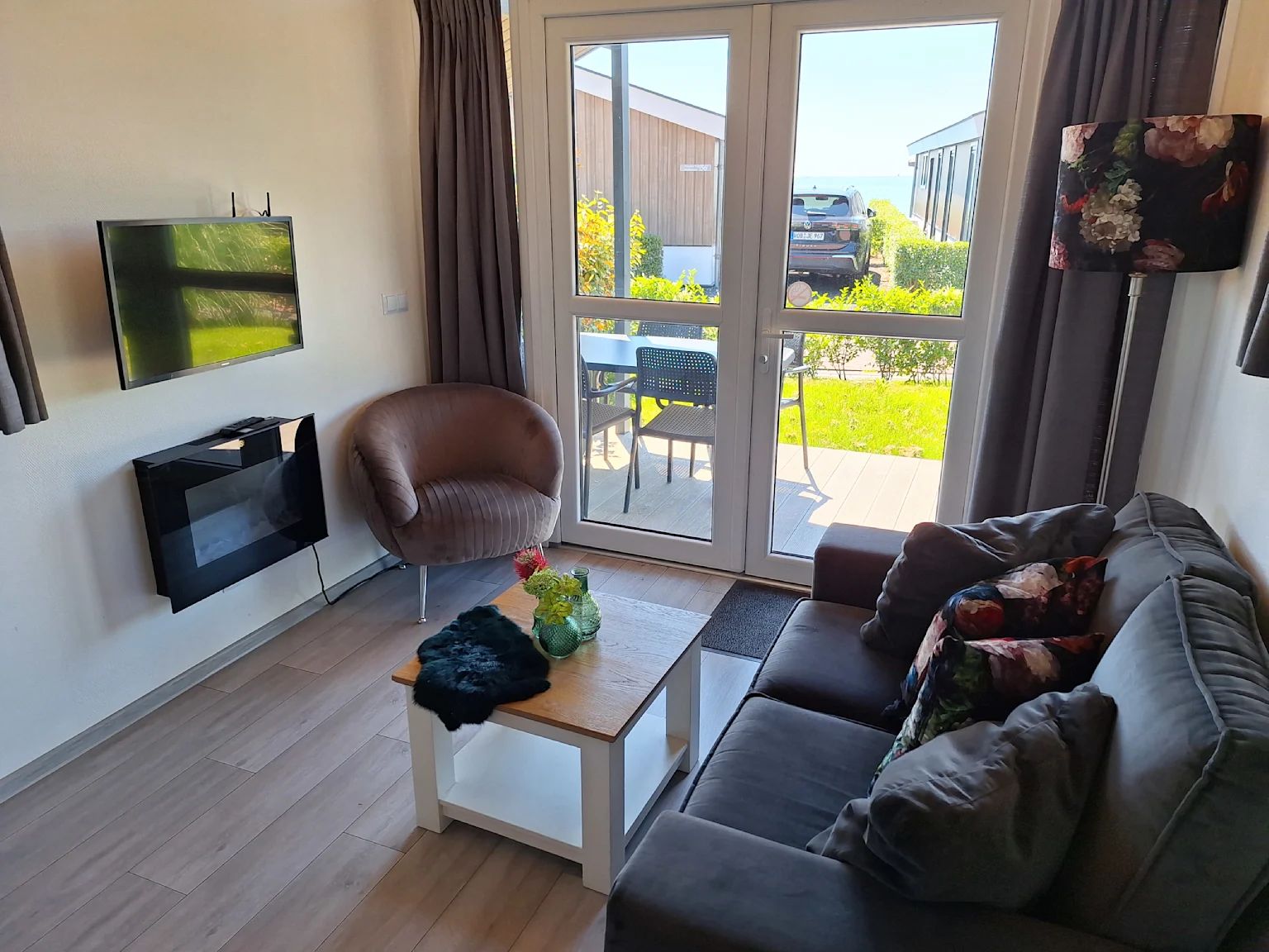 Gezellige woonkamer in Vrijstaande woning in Bovenkarspel, vakantiehuis aan de IJsselmeerkust, Noord-Holland met uitzicht op terras en tuin.