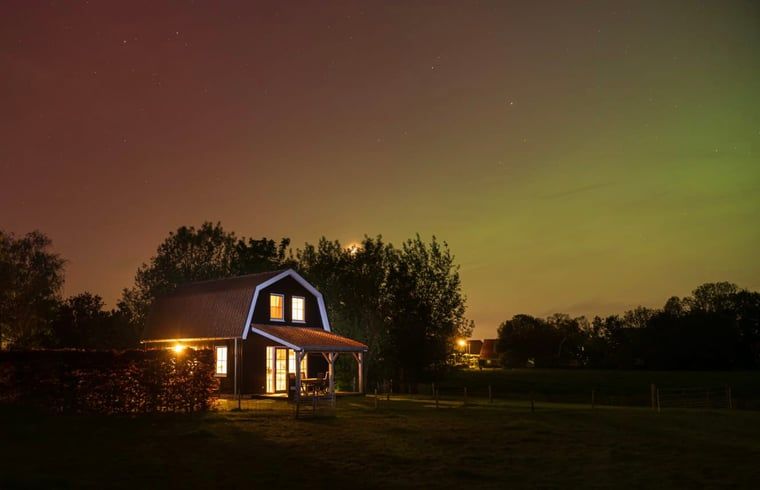Entdecken Sie die ruhige Nachtatmosphaere im Ferienhaus in Schellinkhout, Nordholland, mit einem wunderschoen beleuchteten Himmel ueber dem Ferienhaus.
