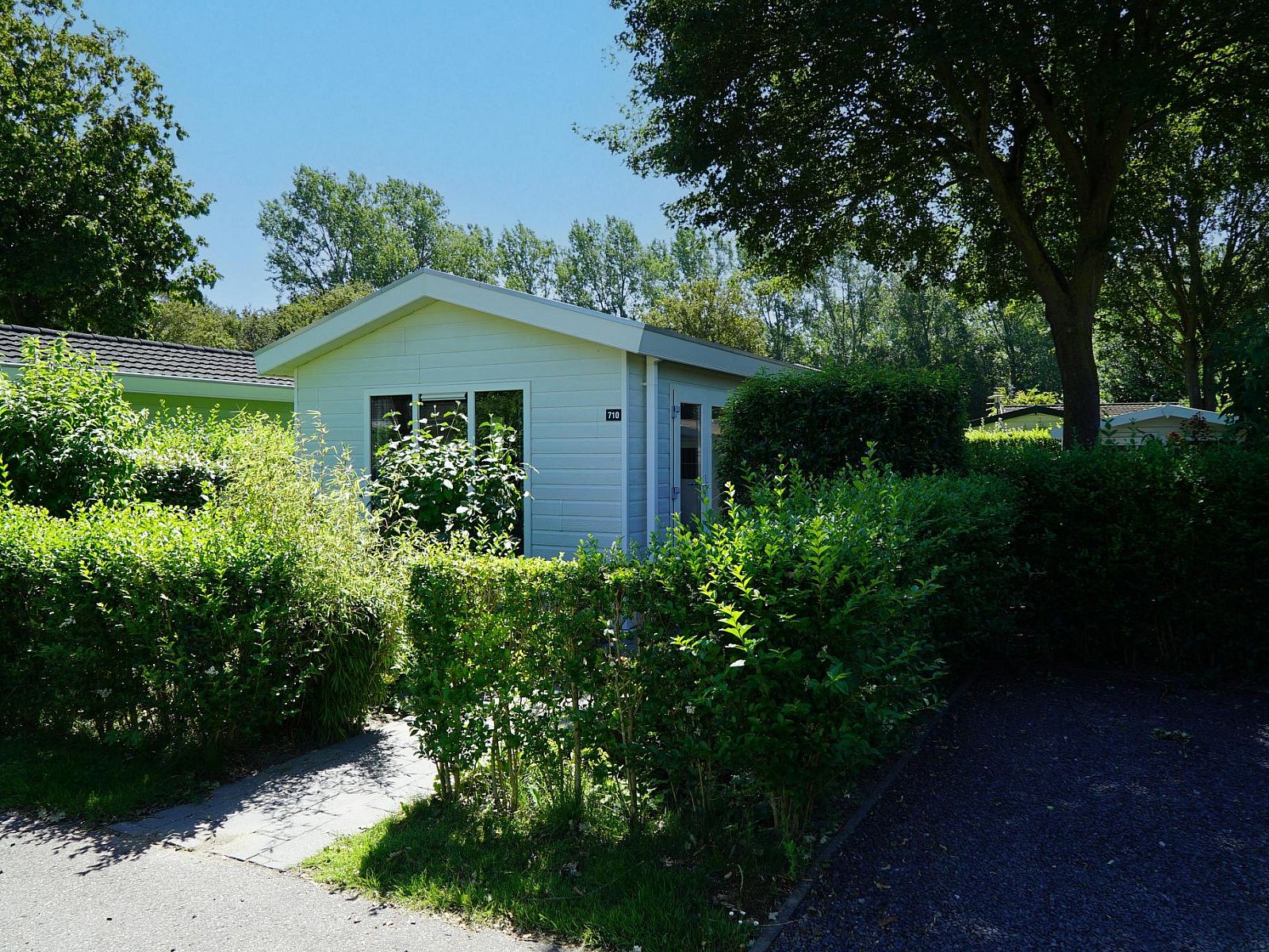 Vakantiehuis Unique 4 in Noord-Scharwoude, Noord-Holland, omgeven door groene natuur en bomen, ideaal voor een rustige ontsnapping.