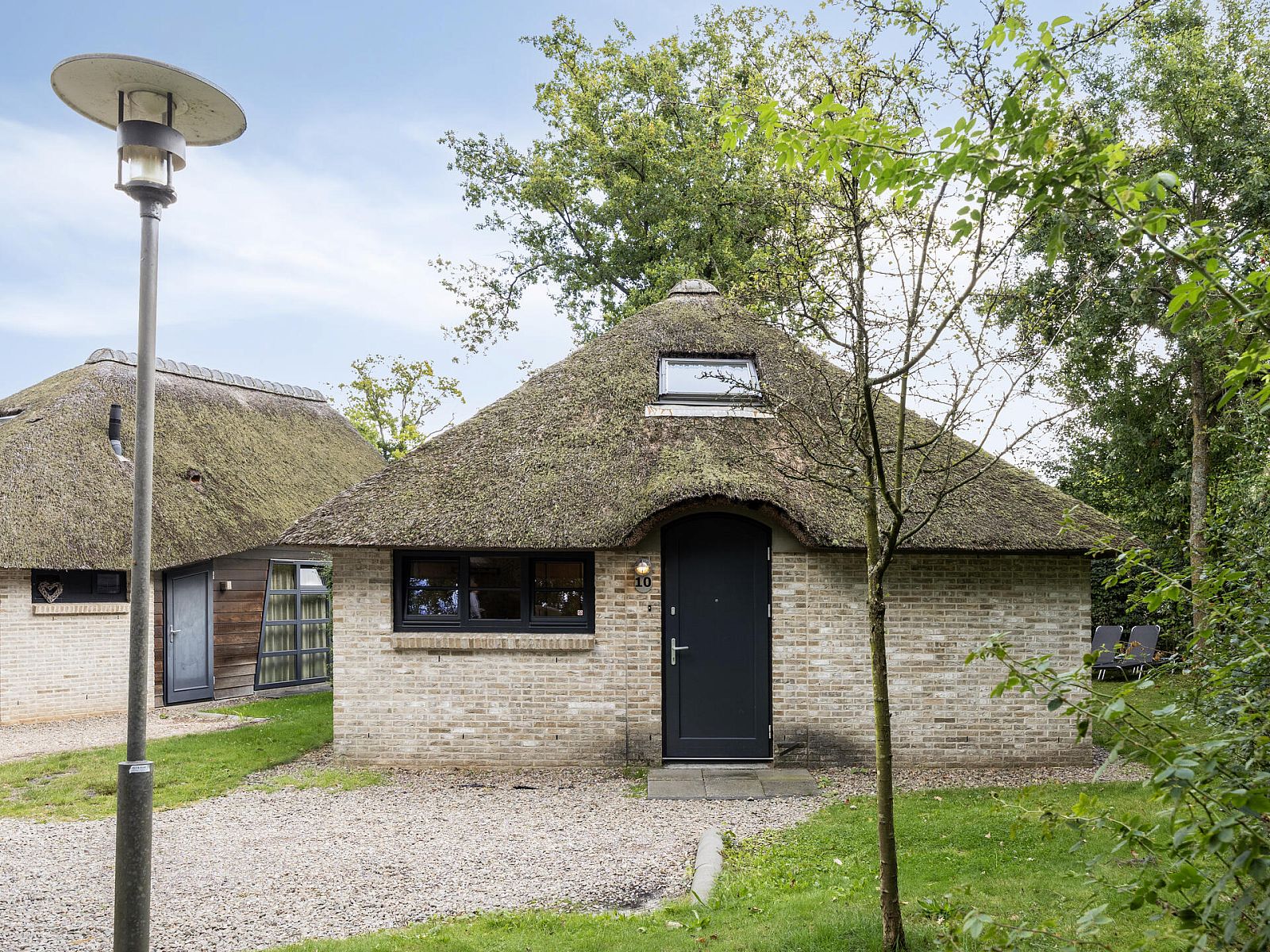 Vrijstaande woning in Schoorl, Noord-Holland, biedt een charmant vakantiehuis met rieten dak, omgeven door groene natuur en rustieke omgeving.