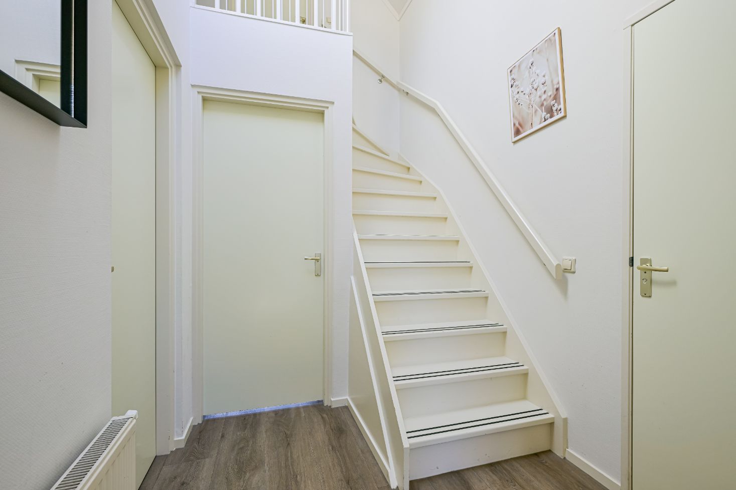 Heldere hal met trap in de Vrijstaande woning in Schoorl, Noord-Holland noord, ideaal vakantiehuis voor gezinnen.