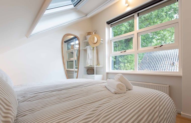 Slaapkamer met comfortabel bed in Huisje in Schoorl, Noord-Holland noord.