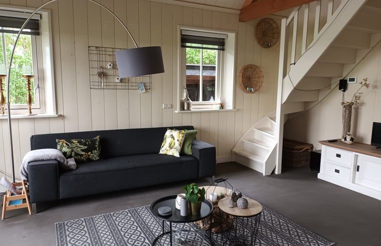 Gemuetliches Wohnzimmer im Huisje in Winkel, einem Ferienhaus in Nordholland Nord. Gemuetliche Sitzecke mit modernen Moebeln und natuerlichem Licht.