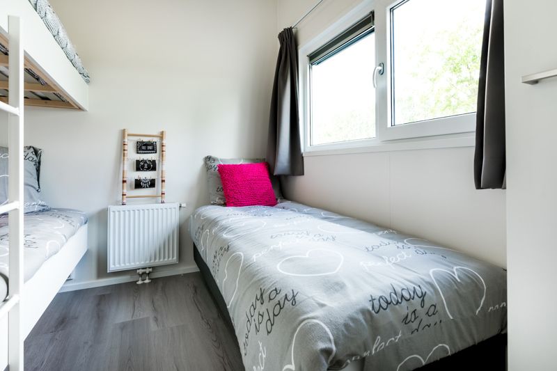 Gemuetliches Schlafzimmer im Modul 5-Personen-Ferienhaus in Berkhout, Nordholland, mit bequemen Betten und Tageslicht.