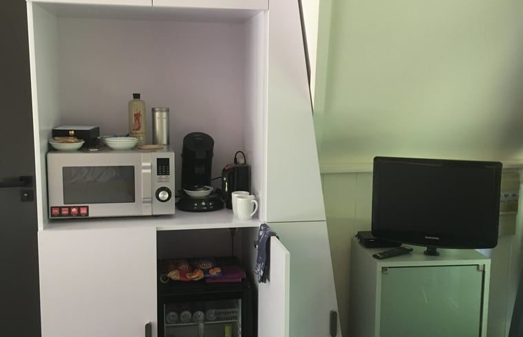 Kuechenausstattung im Ferienhaus in Aartswoud, Nordholland, mit Mikrowelle und Kaffeemaschine.