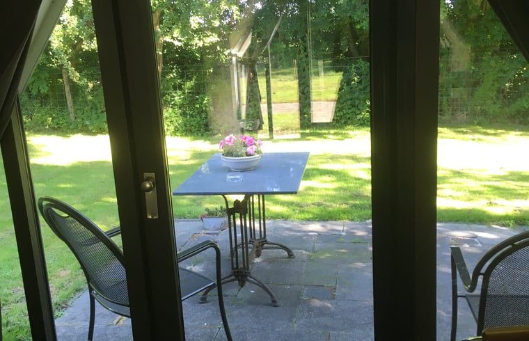 Veranda des Ferienhauses in Aartswoud, Nordholland, mit Blick auf den Garten.