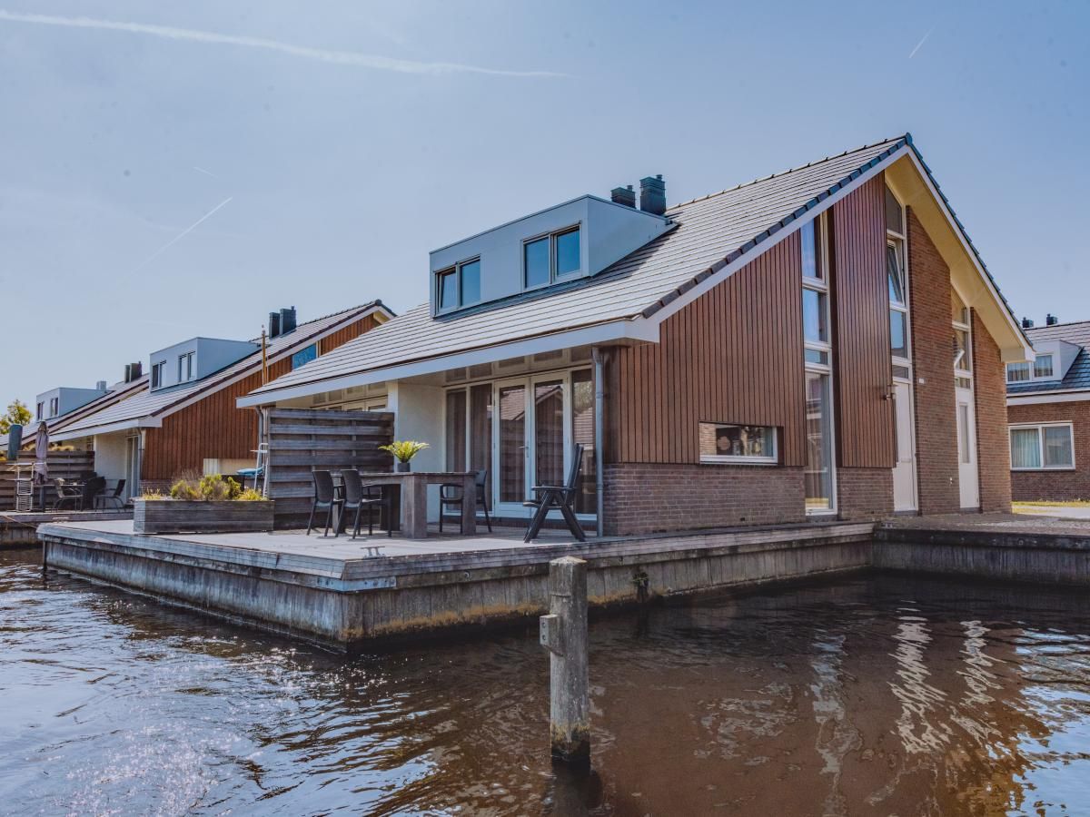 Ferienhaus Busch en Dam in Uitgeest, Nordholland, mit Terrasse am Wasser, ideal zum Entspannen und Natur erleben.