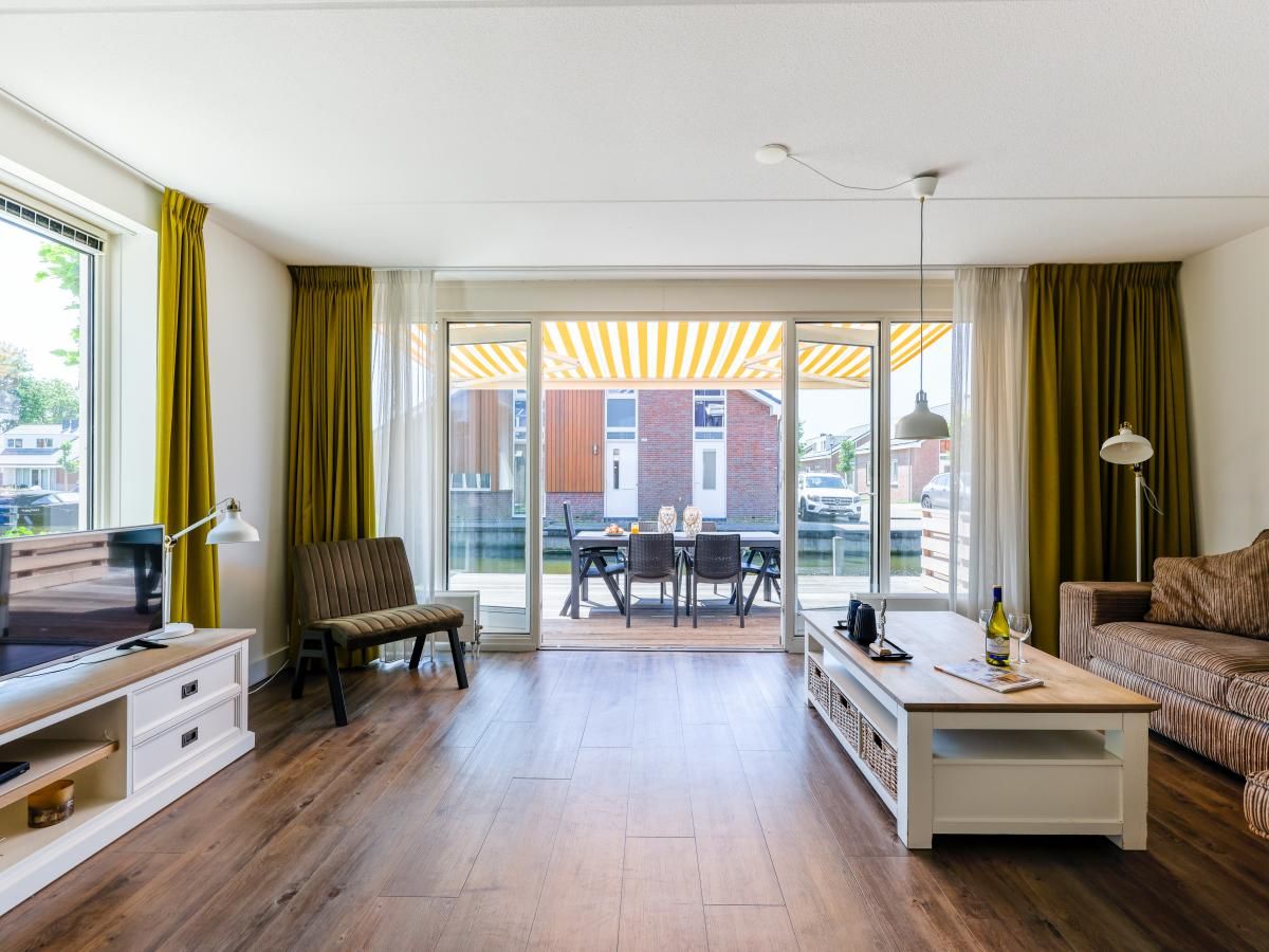 Spacious living room of Apartment Assum I in Uitgeest, North Holland, with a view of the terrace and modern furnishings for a relaxing stay.