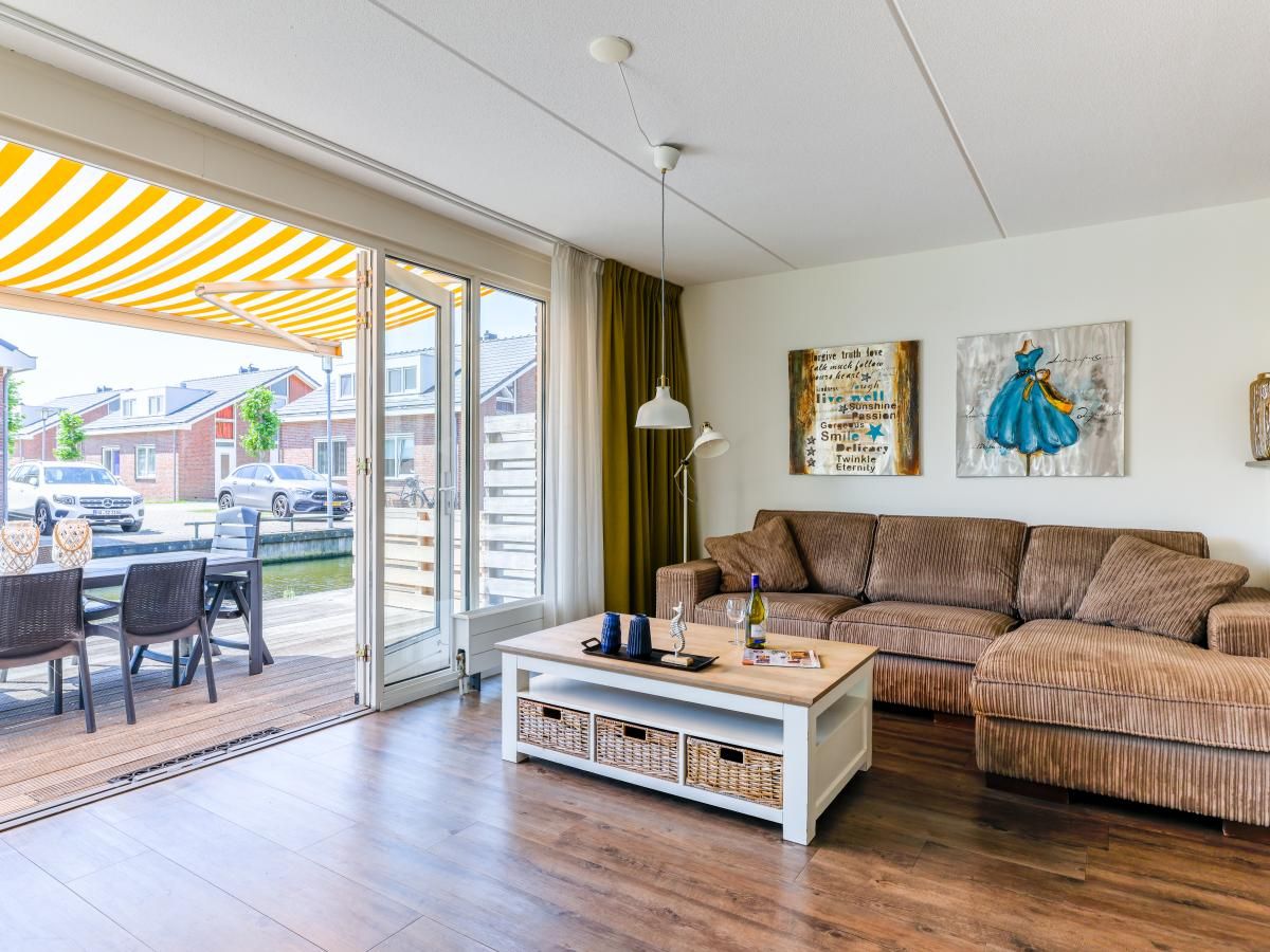 Cozy living room of Apartment Assum I in Uitgeest, North Holland, with comfortable seating area and view of the sunny terrace.