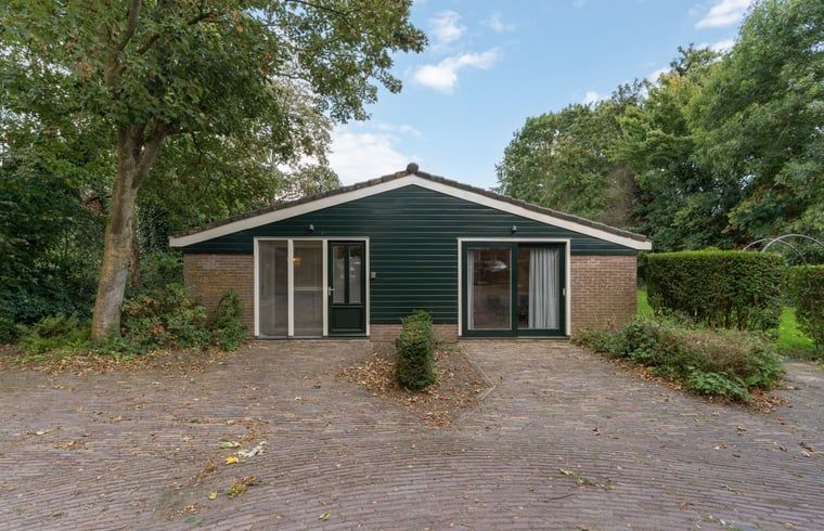 Vakantiehuis in Heiloo, Noord-Holland met groene gevel en omringd door natuur, ideaal voor een ontspannen verblijf in een prachtige omgeving.