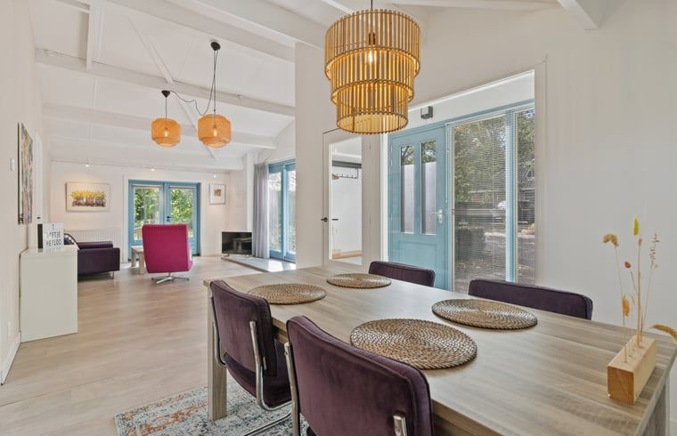 Stijlvolle eetkamer in Vakantiehuis in Heiloo, Noord-Holland, met moderne inrichting en uitzicht op de groene omgeving.