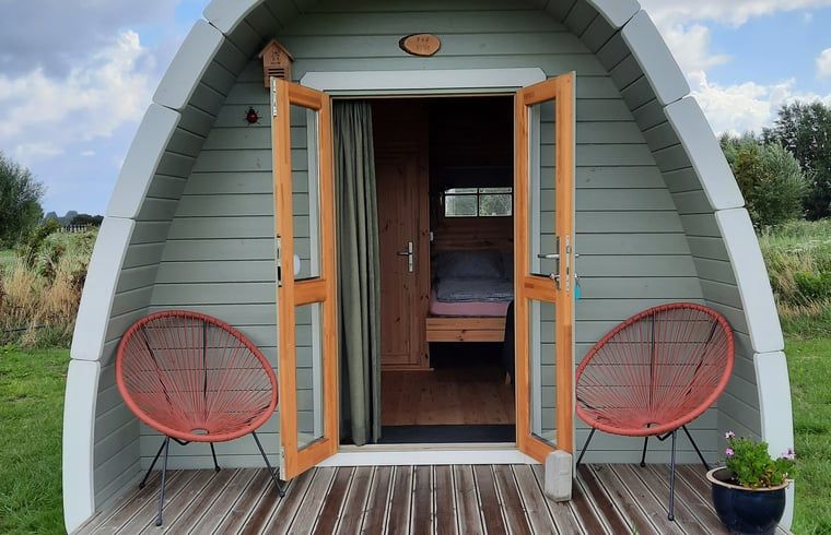 Openstaande deuren van Huisje in Zuid-Scharwoude, een vakantiehuis in Noord-Holland, met uitnodigend interieur.