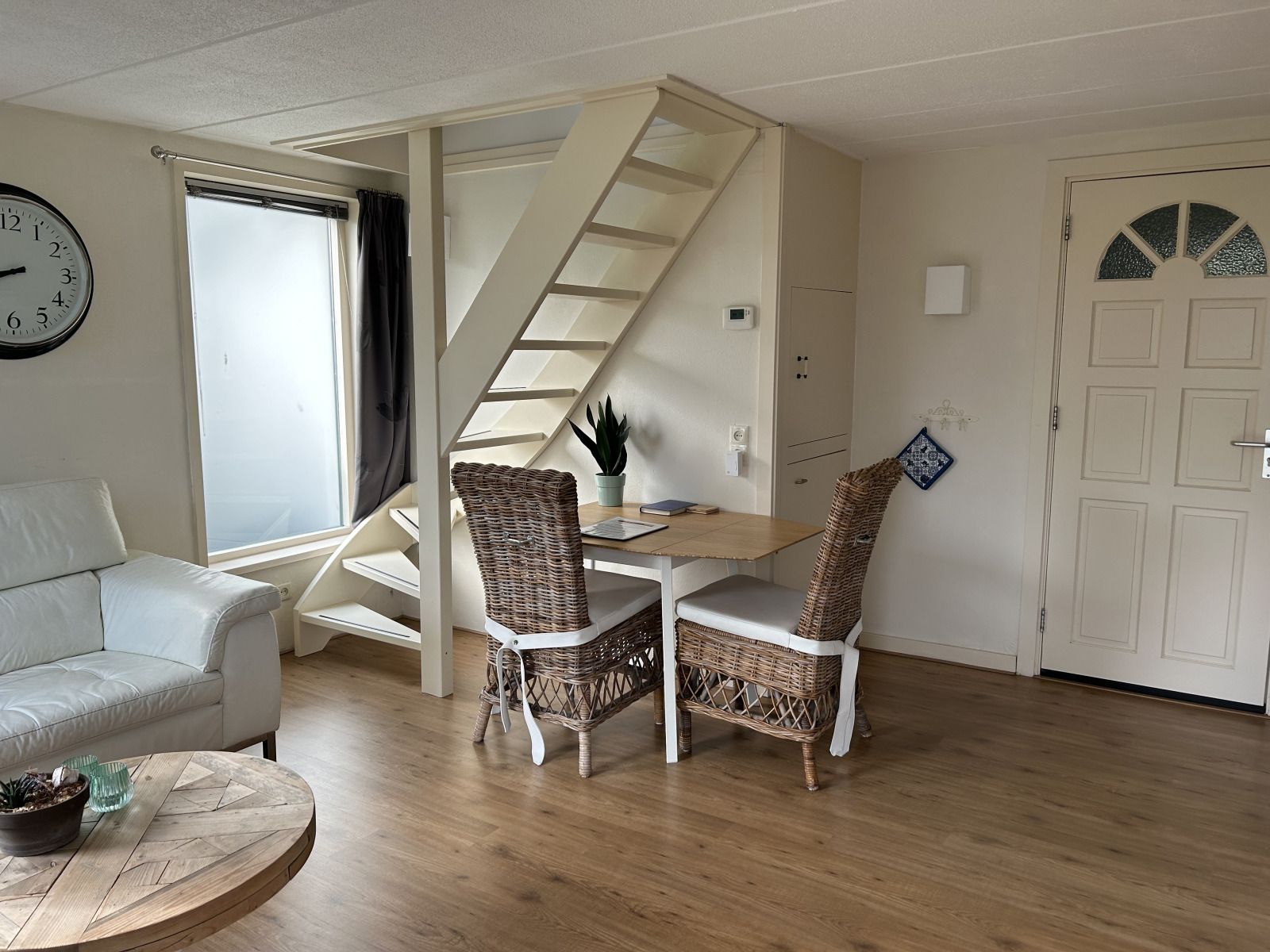 Sonnenterrasse des Ferienhauses NH539 in Spanbroek, Nordholland mit Blumen und Sitzgelegenheit