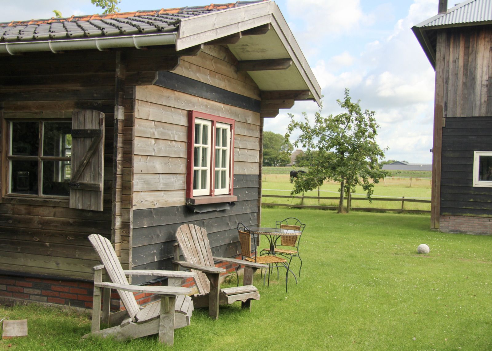 NH550 vakantiehuis in Heerhugowaard met knusse houten veranda en groene tuin in Noord-Holland.