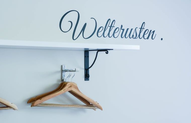 Garderobe in Cottage in Mander, Mander, Twente, mit inspirierendem Text und Holzbuegeln.