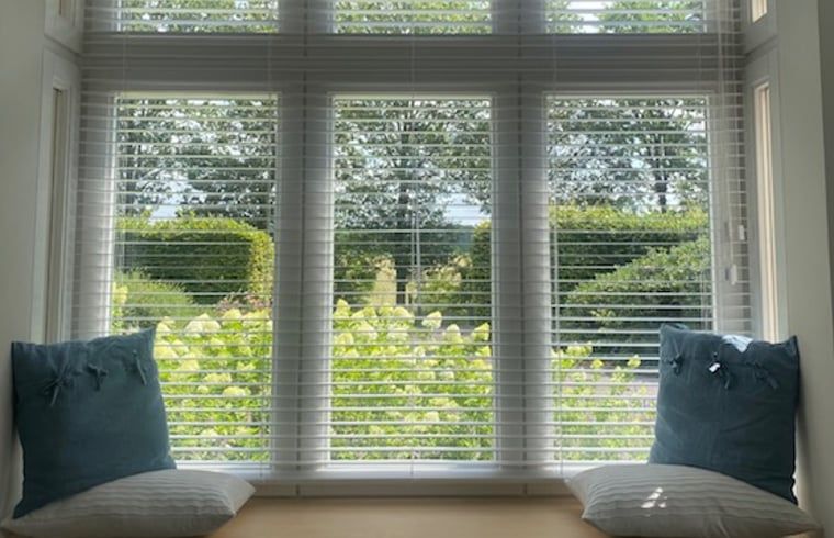 Fensterplatz im Ferienhaus in Mander, Twente, Overijssel, mit Blick auf den gruenen Garten und viel natuerliches Licht.