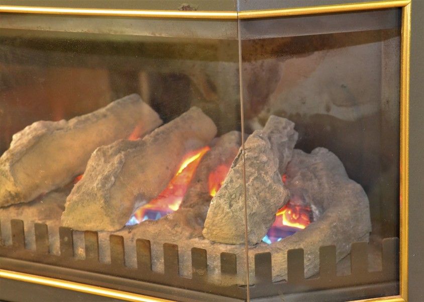 Sfeervolle open haard in Hosta vakantiehuis in Ootmarsum, Twente voor een gezellige ambiance.