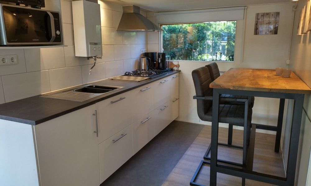 Moderne keuken van Hosta vakantiehuis in Ootmarsum, Twente met eethoek en inbouwapparatuur.