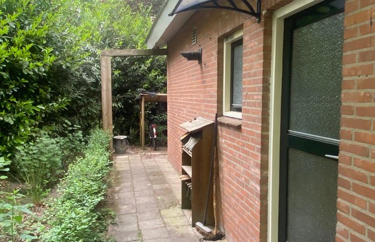 Seitenweg zum Eingang von Huisje in Nutter, Ferienhaus in Nutter, Twente, mit gruener Umgebung.