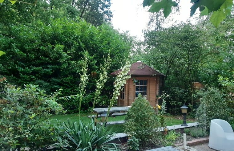 Prachtige tuin met houten tuinhuis bij Vakantiehuis in Nutter, Twente, omringd door groen.