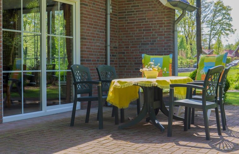 Sonnige Terrasse mit Gartenmoebeln im Ferienhaus in Nutter, Twente, fuer einen entspannten Urlaub in Overijssel.