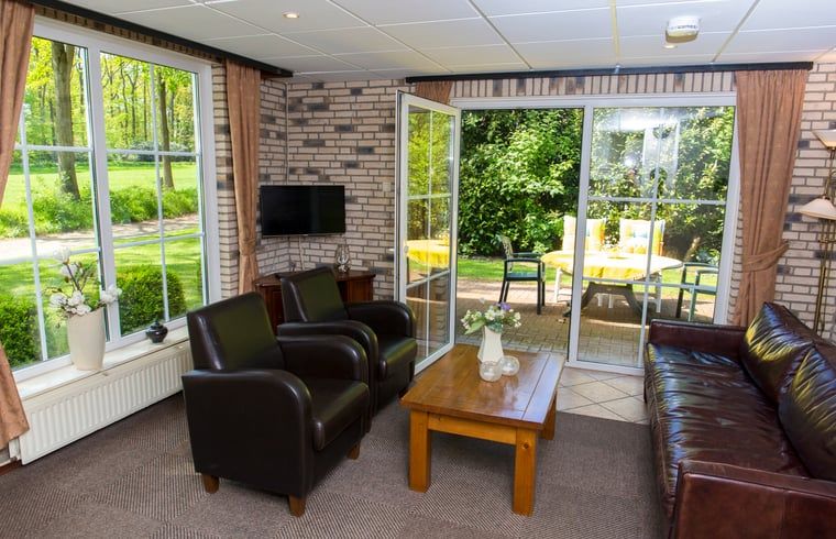 Gemuetliches Wohnzimmer im Ferienhaus in Nutter, Twente, mit Blick auf den Garten in Overijssel.