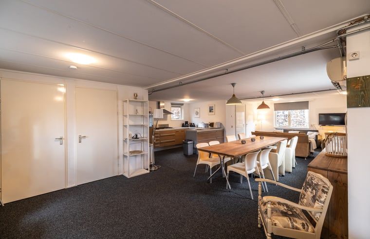 Gemuetlicher Innenbereich von Huisje in Den Ham, einem Ferienhaus in Twente, Overijssel, mit einer geraeumigen Kueche und einem Esstisch aus Holz.