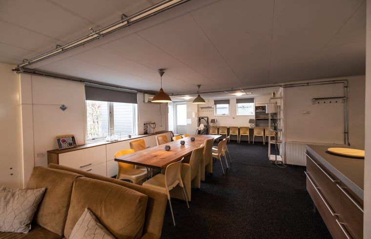 Gemuetliches Wohnzimmer in Cottage in Den Ham, Ferienhaus in Twente, Overijssel, mit geraeumiger Sitzecke und grossem Esstisch fuer einen entspannten Aufenthalt.