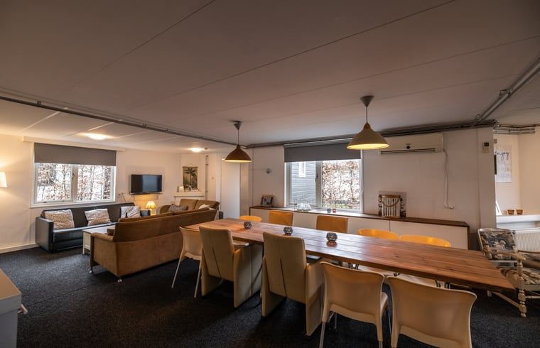 Gemuetliches Ferienhaus Cottage in Den Ham in der gruenen Natur von Twente, Overijssel, mit einladender Veranda und umgeben von ueppiger Vegetation.