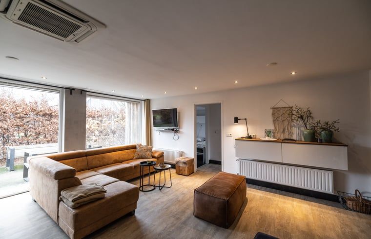 Cozy living room in Holiday Home in Den Ham, Twente, with comfortable seating area and views of the nature of Overijssel.