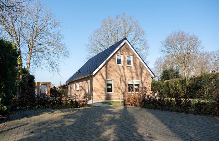Vooraanzicht van Vakantiehuisje in Den Ham, Twente, met ruime oprit en omringende natuur.