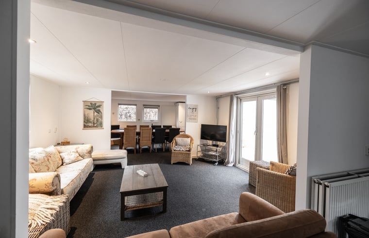 Gezellige woonkamer van Vakantiehuis in Den Ham, Twente, Overijssel met comfortabele zithoek en ruime eethoek voor een ontspannen verblijf.