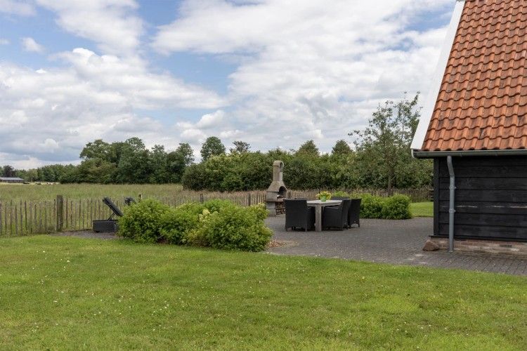 Geniessen Sie die Ruhe und den Frieden im Assenhoekje in Den Ham, Twente. Entspannen Sie sich auf der Terrasse dieses Ferienhauses mit Blick auf gruene Felder.