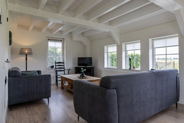 Stilvolles Wohnzimmer im Ferienhaus Het Assenhoekje, Den Ham, Twente. Gemuetlicher Innenraum mit komfortablen Moebeln und Blick auf die Natur.