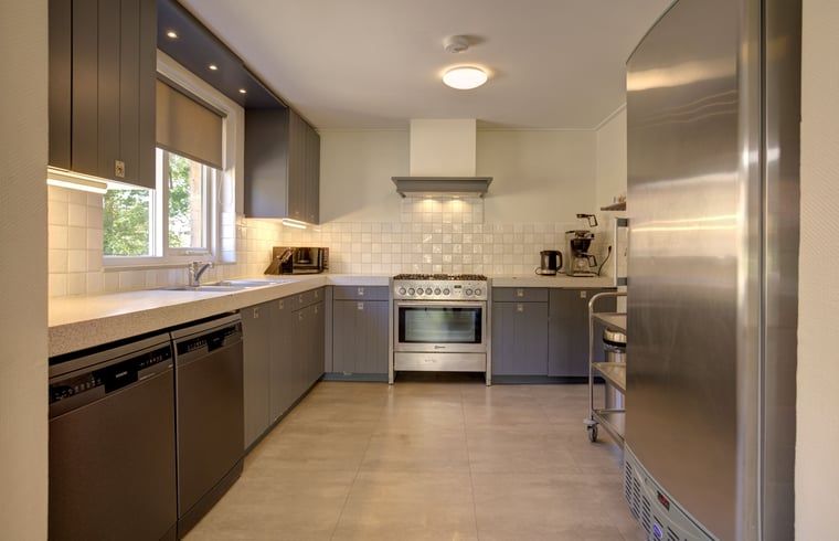 Gemuetliches Esszimmer im Ferienhaus in de Lutte, Twente, mit Holztisch und moderner Kueche. Perfekt fuer einen entspannten Aufenthalt in Overijssel.