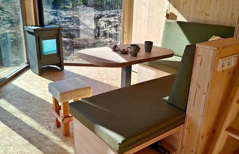 Knusse eethoek met kachel in Vakantiehuisje in de Lutte, Twente, voor een warme sfeer.