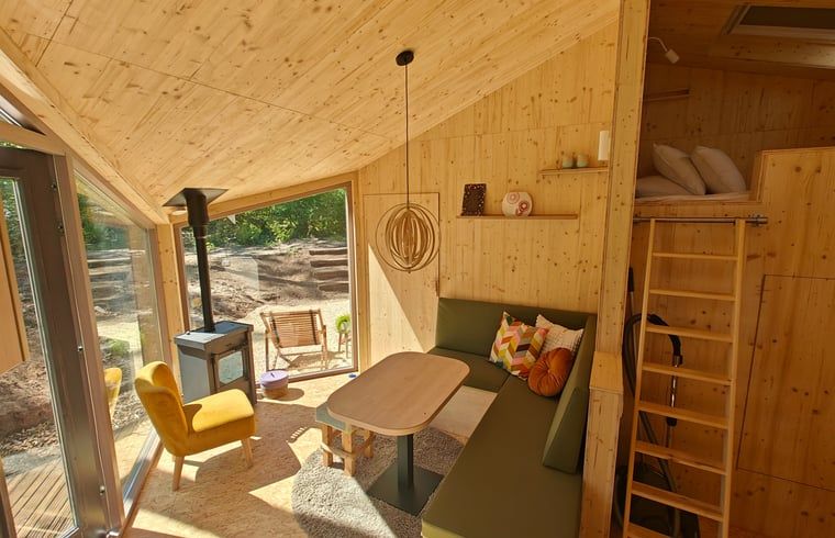 Lichte woonkamer met houtkachel in Vakantiehuisje in de Lutte, Twente, voor ontspanning.