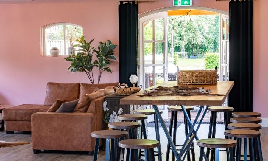 Gemuetliche Sitzecke im Ferienhaus Landgoed Nieuwhuis in Ootmarsum, Twente, mit Blick auf den Garten.