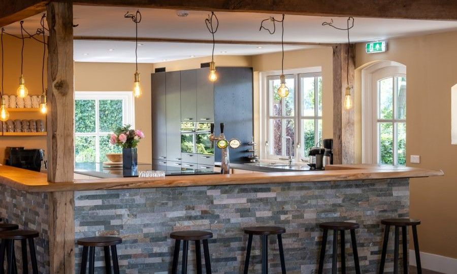 Bar mit Hockern im Ferienhaus Landgoed Nieuwhuis in Ootmarsum, Twente, fuer gemuetliche Abende.