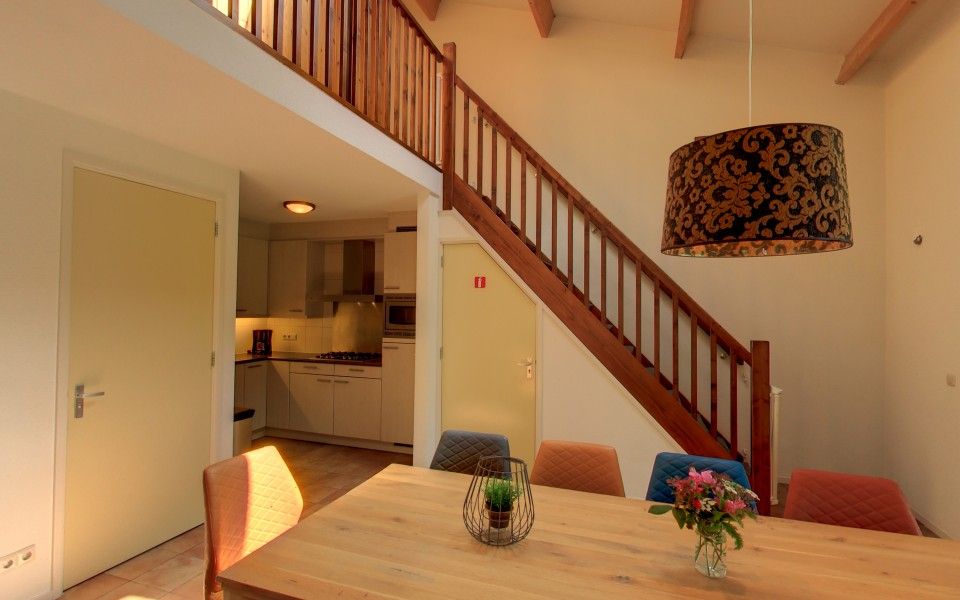 Kitchen and dining area in the Witker vacation home in Ootmarsum, Twente with wooden stairs.