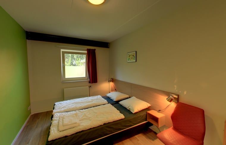 Slaapkamer in vakantiehuisje in Hezingen met tweepersoonsbed, gelegen in Twente, Overijssel.