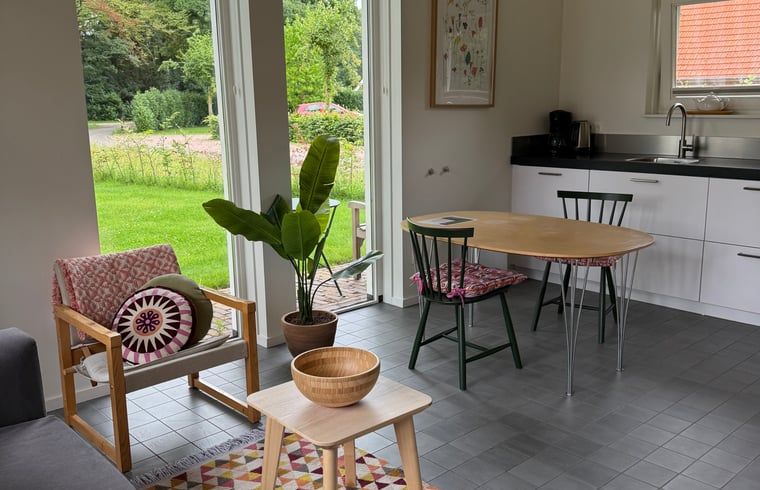 Essecke und Kueche im Ferienhaus in Beuningen mit Blick auf den Garten in Twente, Overijssel.