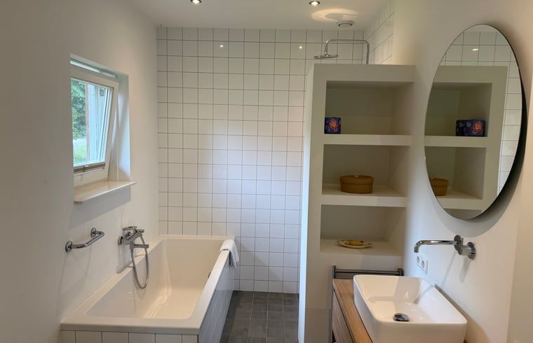 Geraeumiges Badezimmer mit Badewanne und Waschbecken im Ferienhaus in Beuningen, Twente, Overijssel.