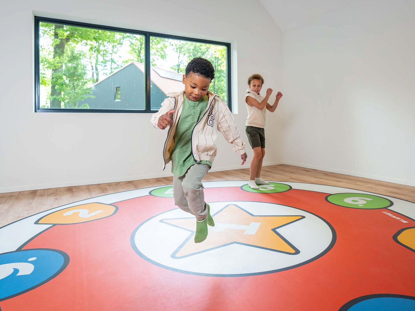 Kinderen spelen in Vrijstaande woning in Beuningen, vakantiehuis in Twente, met kleurrijke vloer.